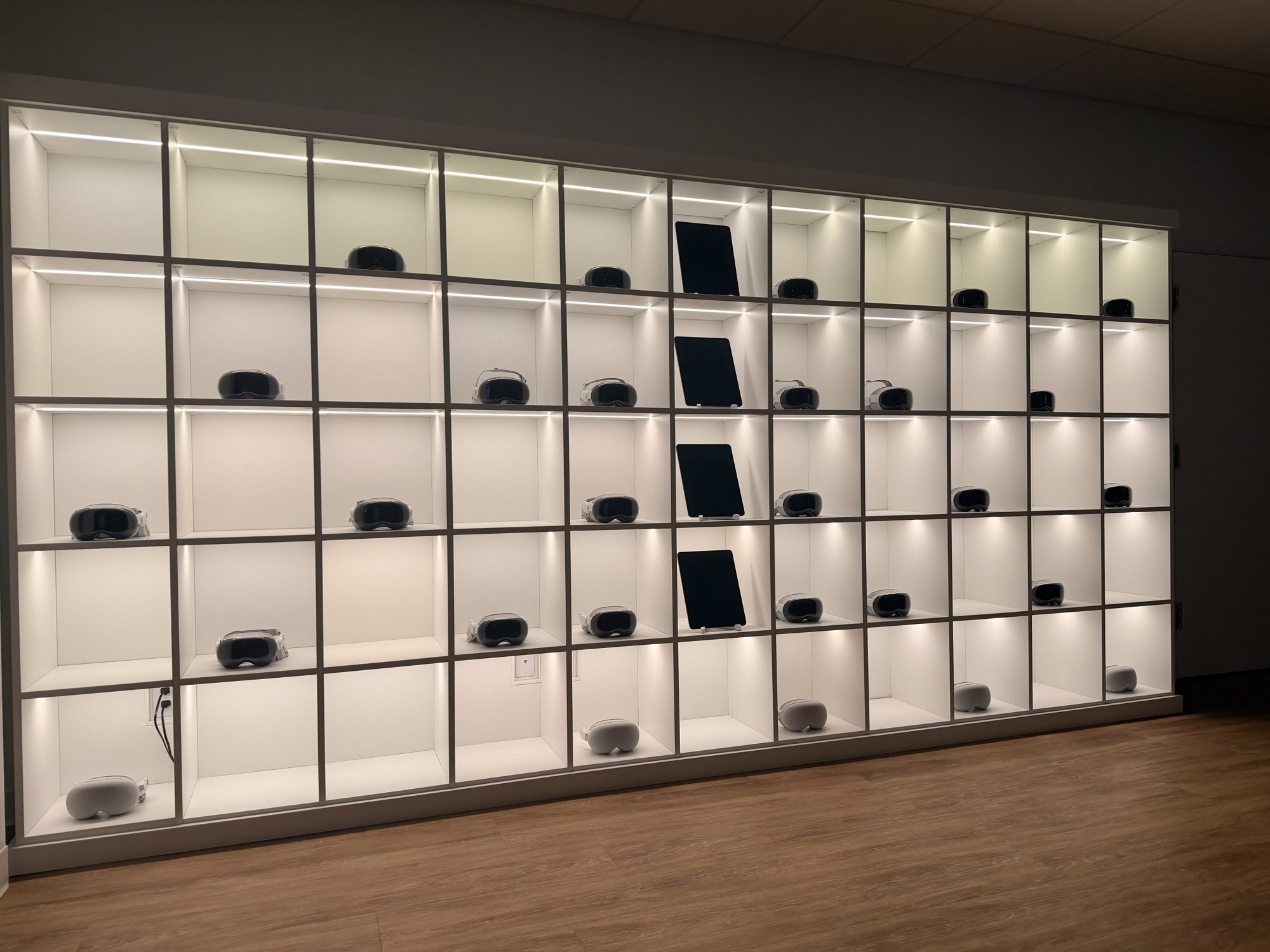 A wall of Apple Vision Pro headsets on shelves